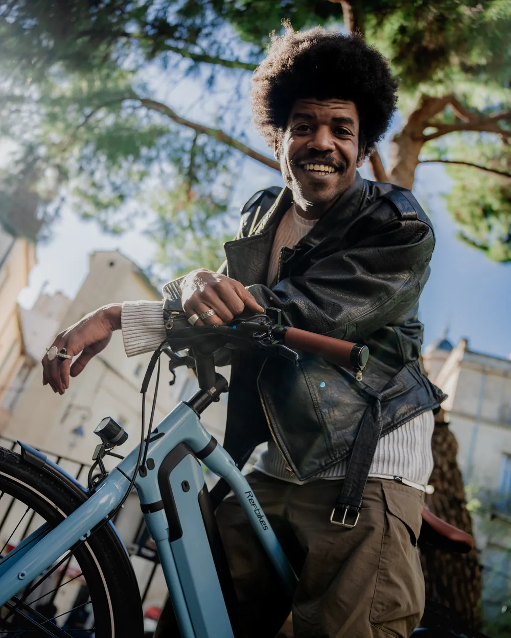 Un homme souriant appuyé sur son vélo REF Bikes