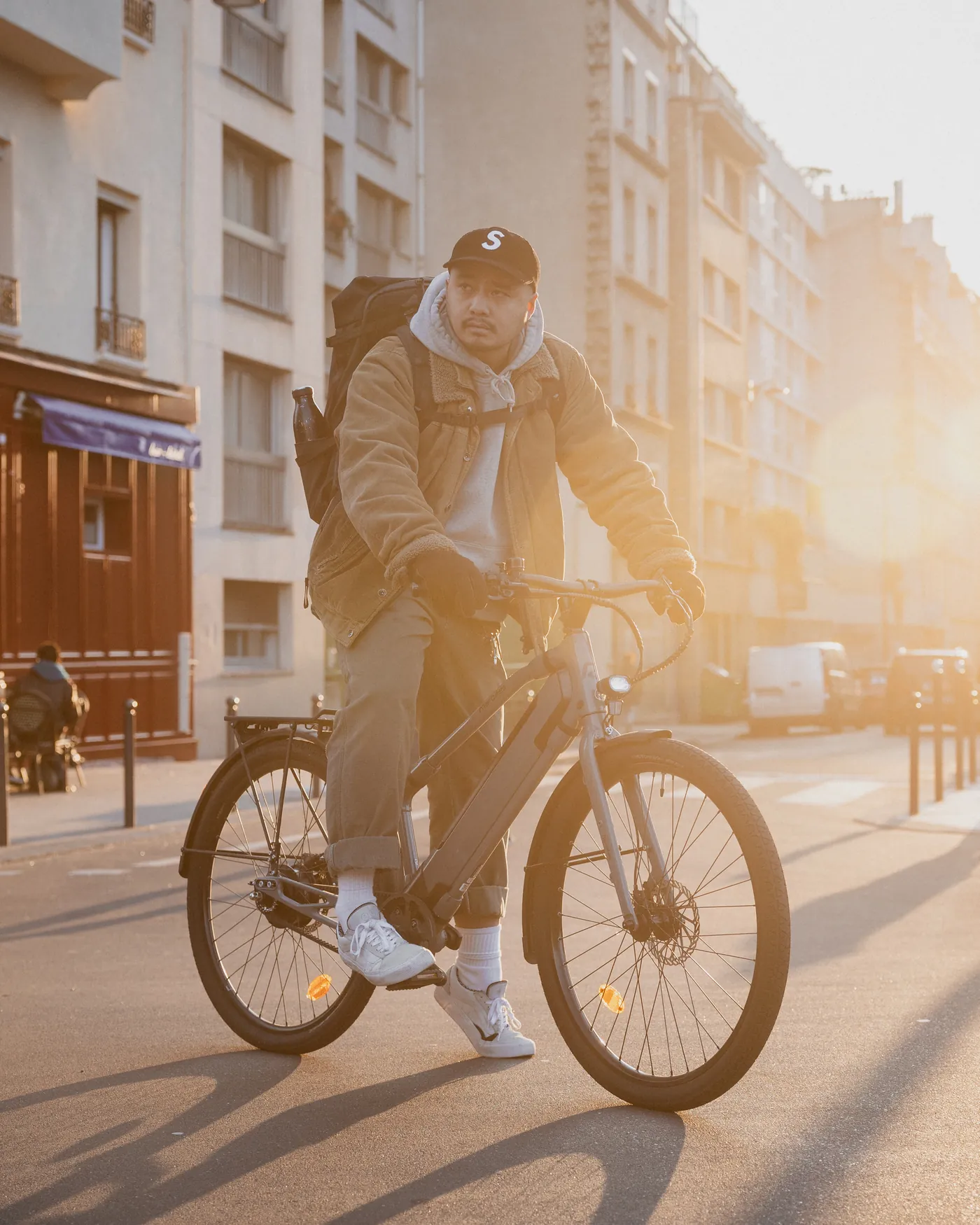 Un cycliste sur un vélo REF Bikes dans une rue, à contre-jour